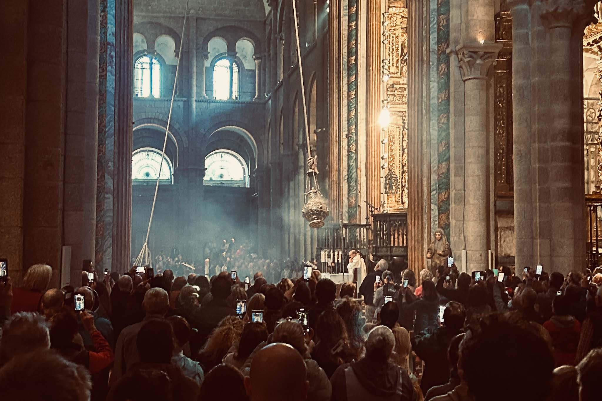 Pilgermesser in der Kathedrale von Santiago de Compostela, Weihrauchkessel in der Mitte und Pilger, die ihn fotografieren